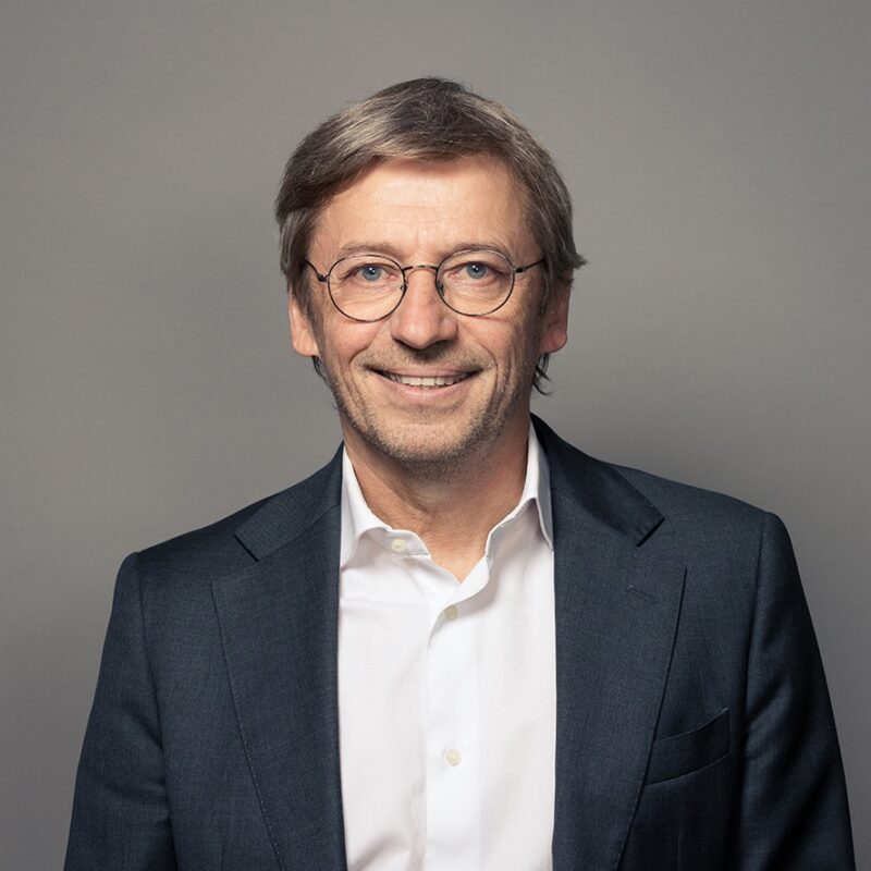 Professional man in suit and glasses smiling for headshot
