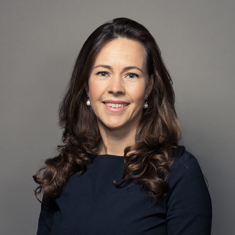 Professional woman with brown hair smiling in business portrait